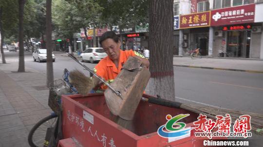 刘新连负责当地两条街的清洁工作,累了路边站会儿,渴了周边商店喝杯水,起早贪黑已成为她的生活习惯。 王惠琳 摄 刘新连负责当地两条街的清洁工作,累了路边站会儿,渴了周边商店喝杯水,起早贪黑已成为她的生活习惯。 王惠琳 摄